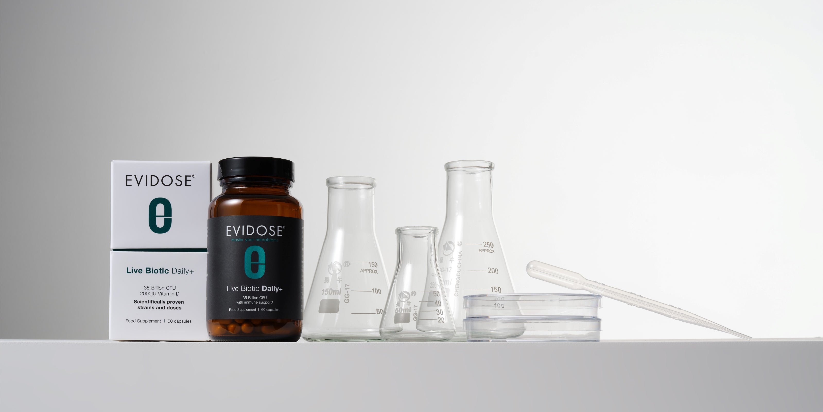 Evidose supplement bottle and packaging with laboratory equipment on a gray background