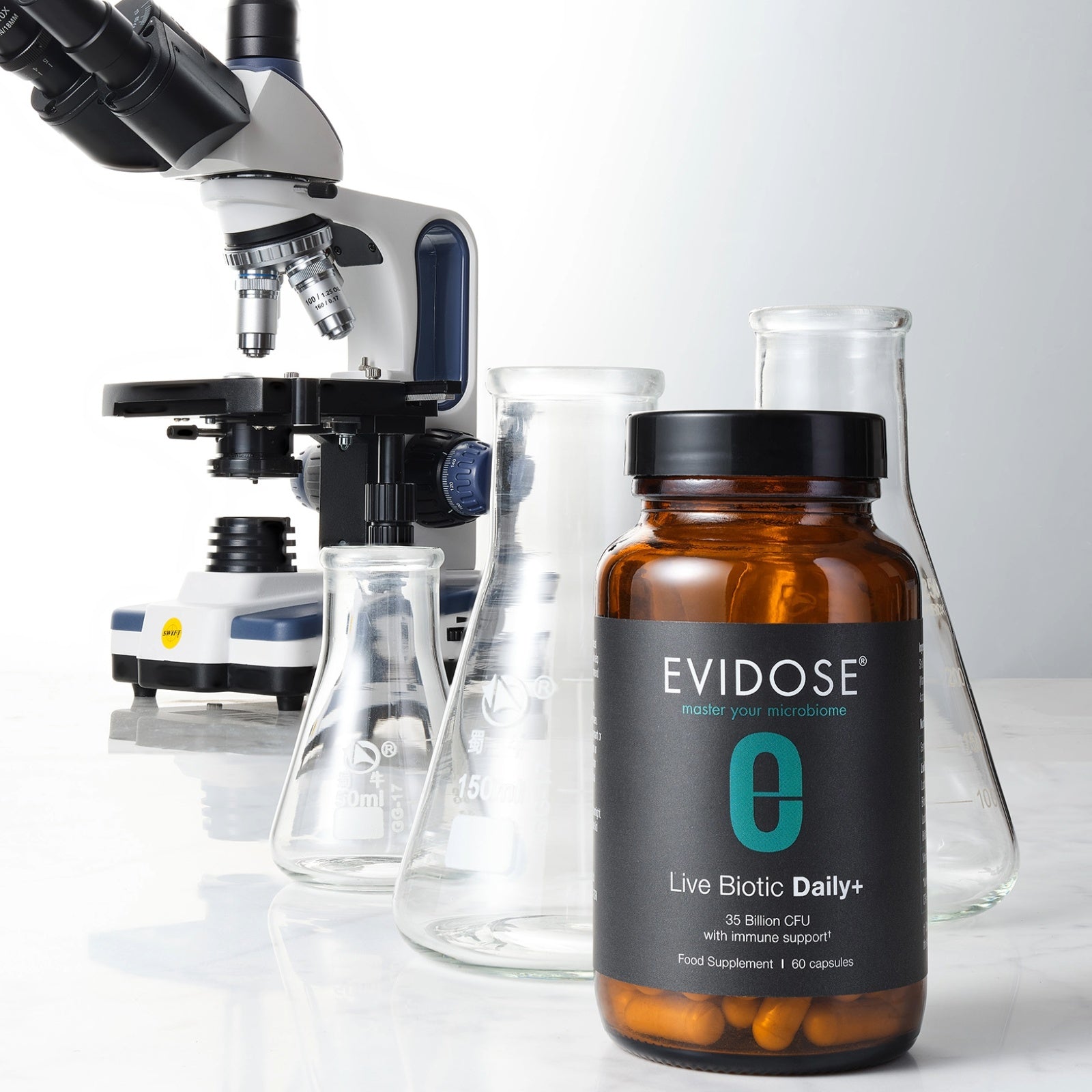 Evidose supplement bottle with a microscope and beakers in the background